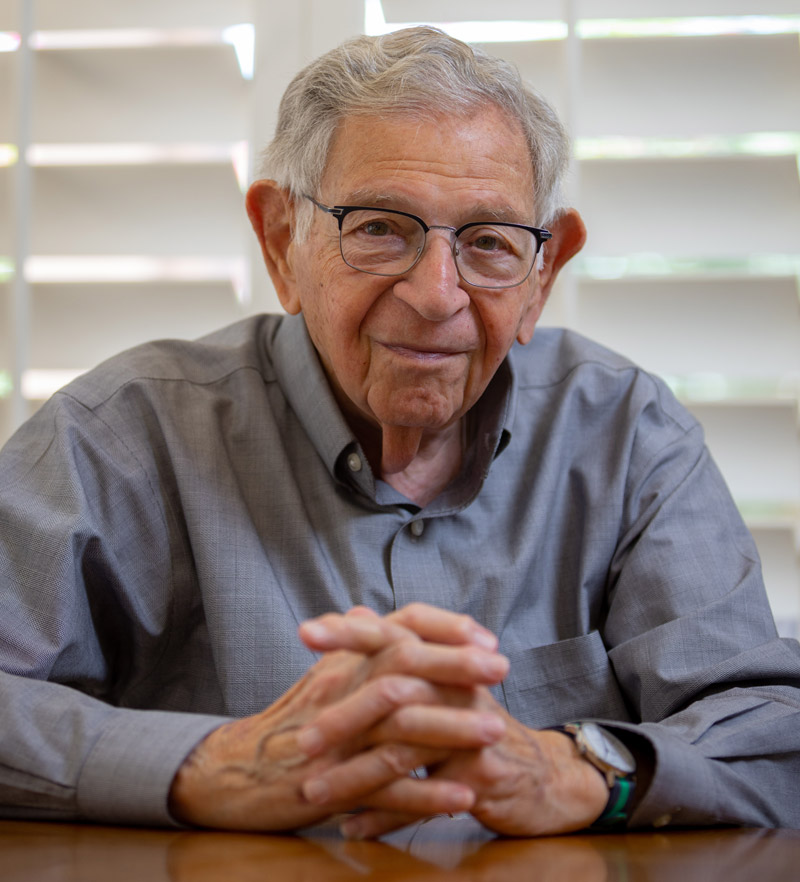 Photo of elderly man with arms on table